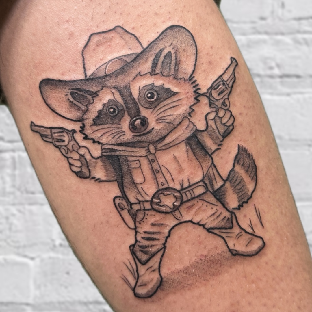 Black and grey cowboy raccoon with revolvers illustrative tattoo