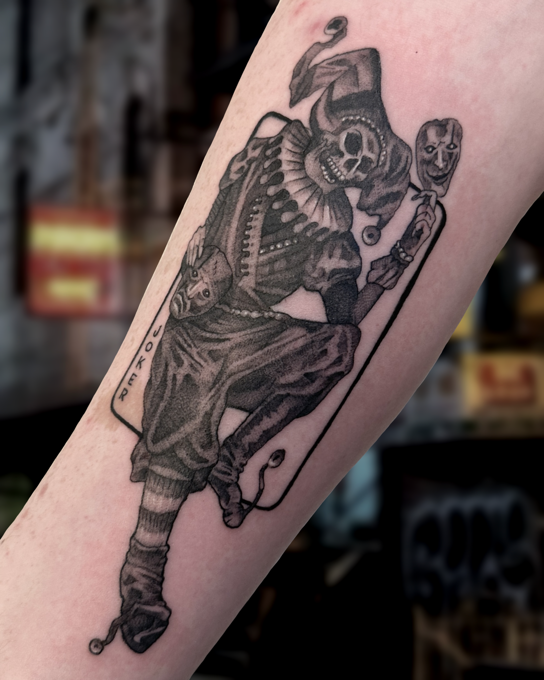 Black and grey joker playing card figure tattoo